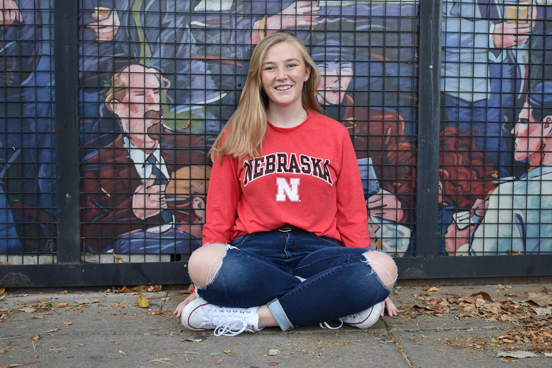 Julia Stephenson poses for a photo in front of a mural.