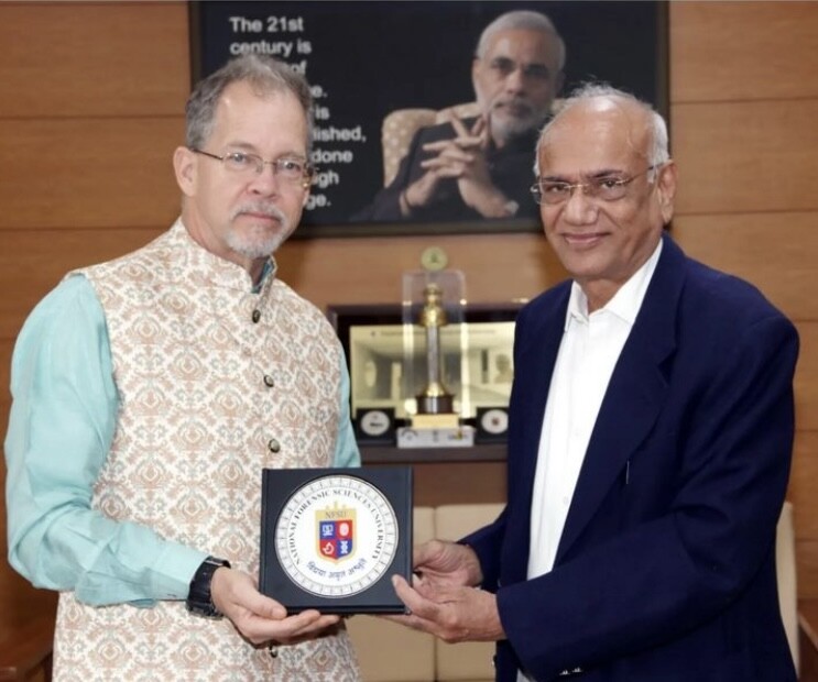 William Belcher with Dr. J.M. Vyas, Vice-Chancellor, National Forensic Science University, Gandhinagar, Gujarat State India. Belcher is being presented with a plaque for a presentation and visit to the Gujarat campus in January 2023.