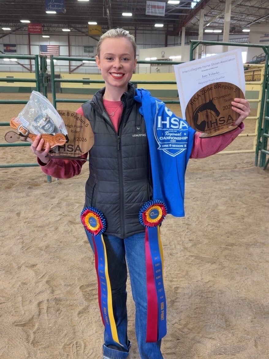 Izzi Velinsky holds up the many awards she's earned in 2026 as a member of the Equestrian Team.
