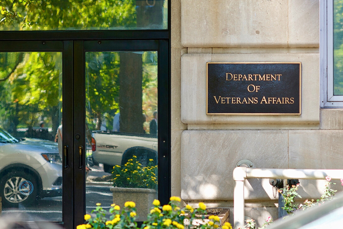 Vehicles are reflected in entrance doors to the Department of Veterans Affairs adjacent to Lafayette Park near the White House.