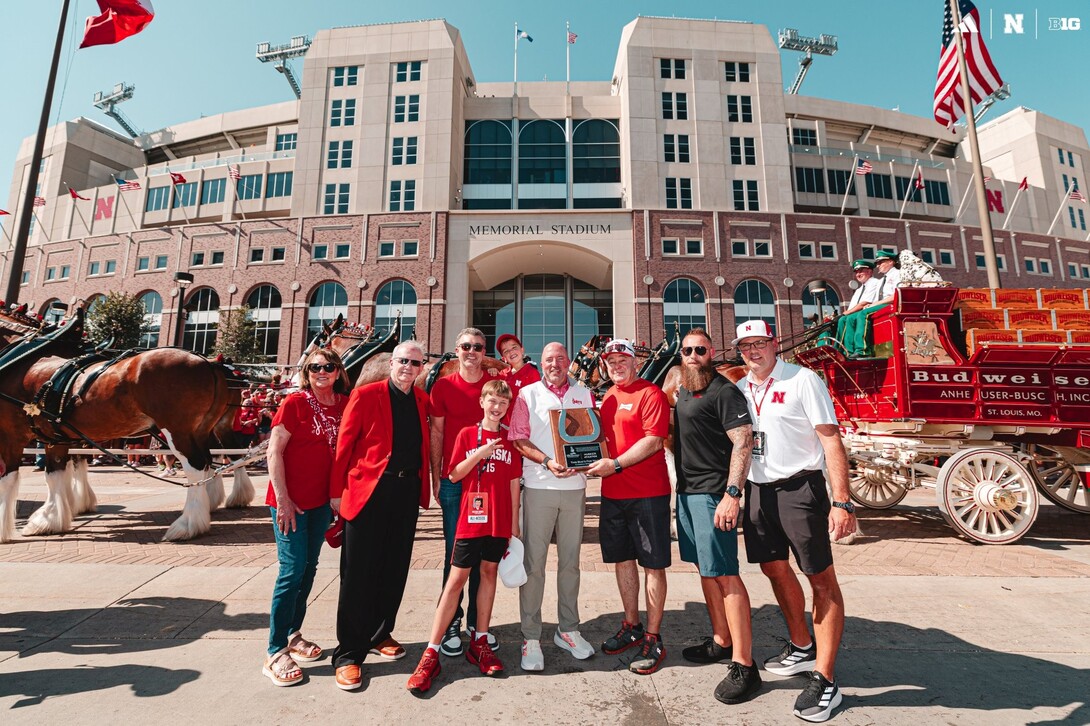 Huskers, including Athletic Director Troy Dannen (middle), standing outside Memorial Stadium during the Budweiser Clydesdale event. Brandon Meier (far right) is Senior Associate Athletic Director of Marketing and Multimedia.