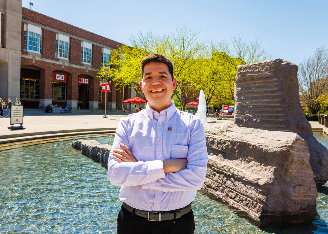 Lupe Perez, the assistant director of campus visits, stands in front of the Nebraska Union and Broyhill Fountain on a sunny spring day. Photo by Kristin Labadie University Communication.