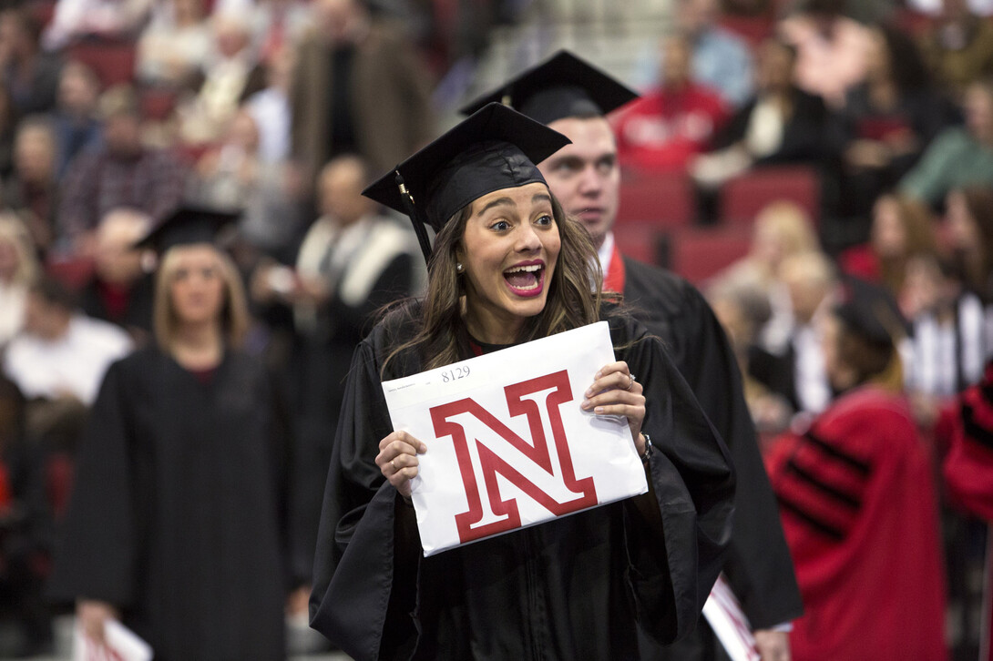 Natalia Santos of Brazil shows off her diploma to friends and family.