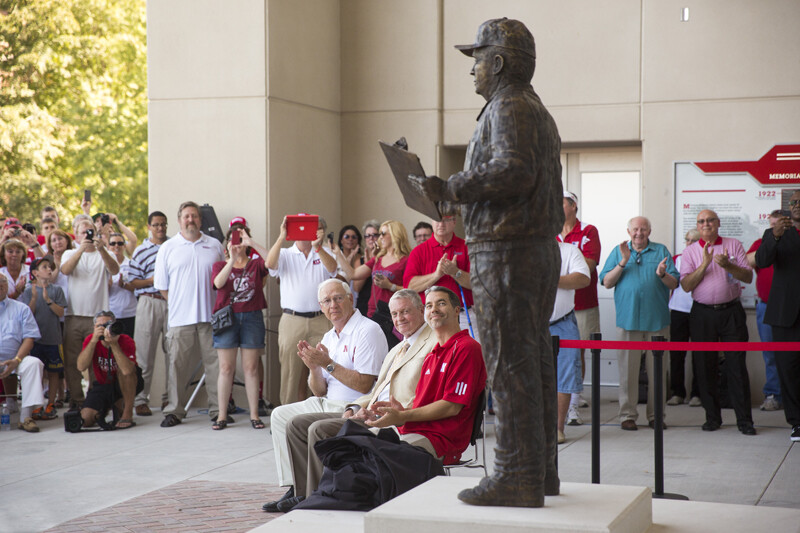 Mike Devaney, (Bob Devaney's son), Tom Osborne, the Cornhuskers' former head coach and athletic director, and Rob Devaney (Bob Devaney's grandson), look up at the just dedicated statue of Bob Devaney.  A commissioned statue of Hall-of-Fame football coach and former Cornhusker athletic director Bob Devaney was installed in the new East Memorial Stadium plaza Friday afternoon. 