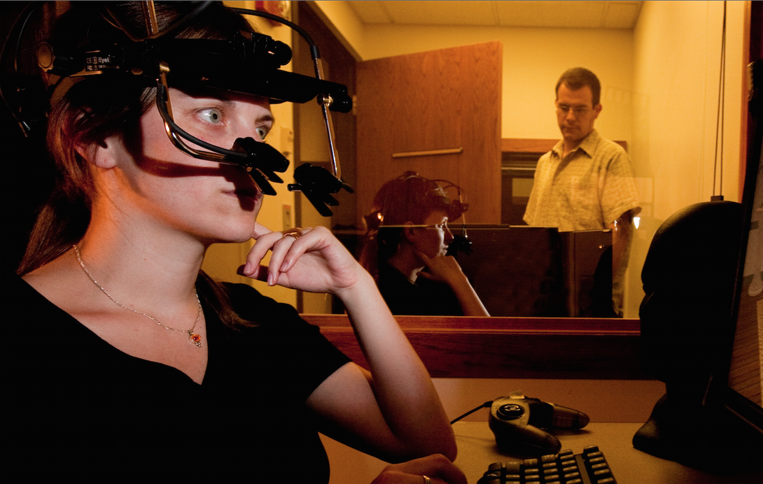 In this file photo, UNL psychology professor Michael Dodd (background) observes a study participant equipped with eyetrack technology.
