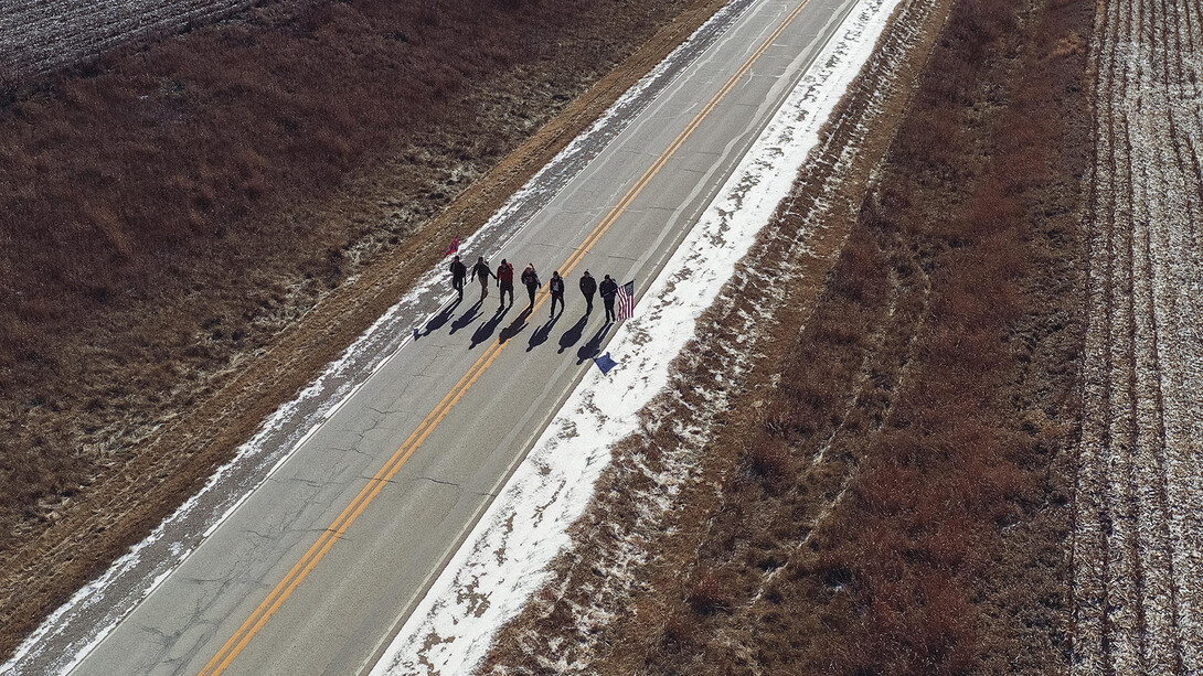 Huskers walk down a rural road during the 2018 Things They Carry Ruck March. The annual event pairs student veterans from Iowa and Nebraska to raise awareness about military suicide.