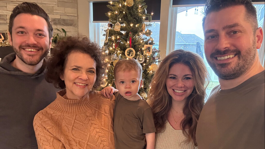 Kayleen Walsh poses for a photo with her children and grandchild. She plans to continue her family’s Husker game day traditions with her grandchildren — which include a new addition in August.