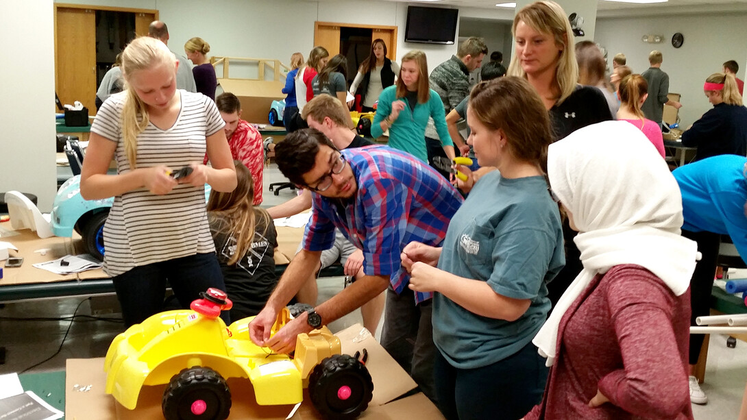 A team of biological systems engineering students works on a car as part of their senior design capstone project. This team is addressing issues to make future Go Baby Go cars easier for the children to operate.