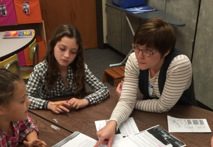 UNL doctoral student and entomologist Erin Ingram works with Evelyn Hamlow Elementary School students Grace Ehlers and Addison Stephens on a project focused on saving honey bees. 