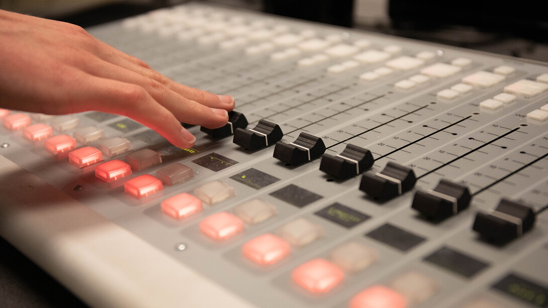 A student adjusts the board in the KRNU studio. The station is intended to allow students to get hands-on experience in the broadcasting industry.
