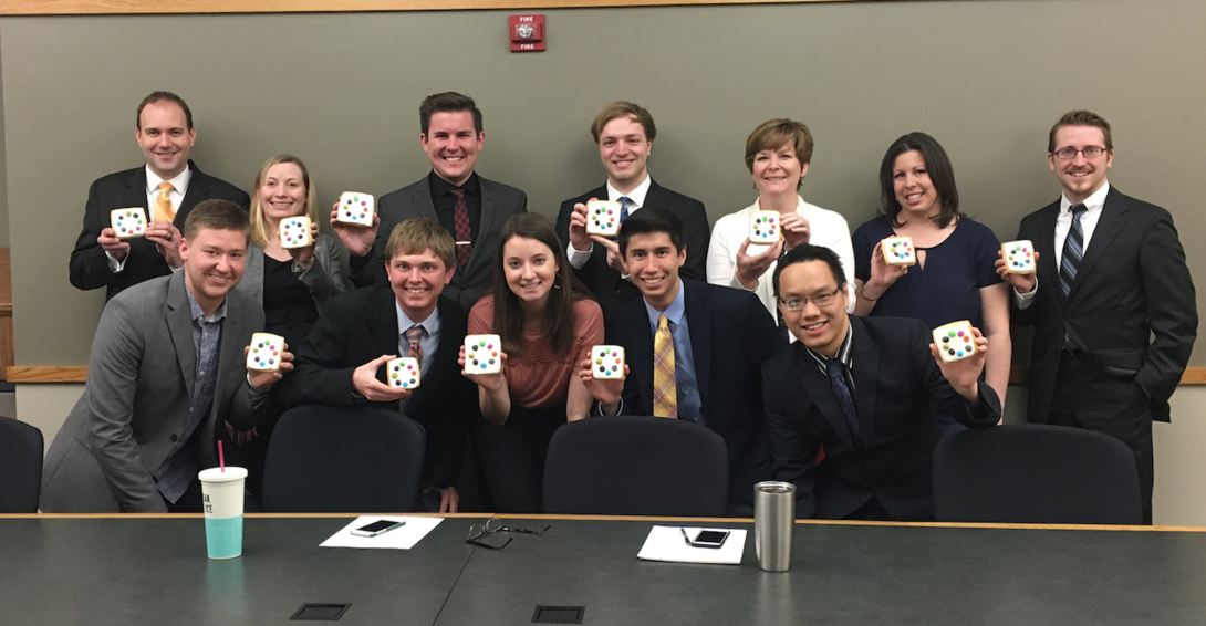 The Design School team that developed the app hold cookies that look like the Build Your Character logo. Back row (left to right): Ian Cottingham, Stephanie Mahlin, Patrick Luddy, Ian Howell, Molly Brummond, Amber Wolff, Eric Sinovec. Front row (left to right): Zach Christensen, Cooper Knaak, Sydney Goldberg, Ryan Long, Quan Tran.