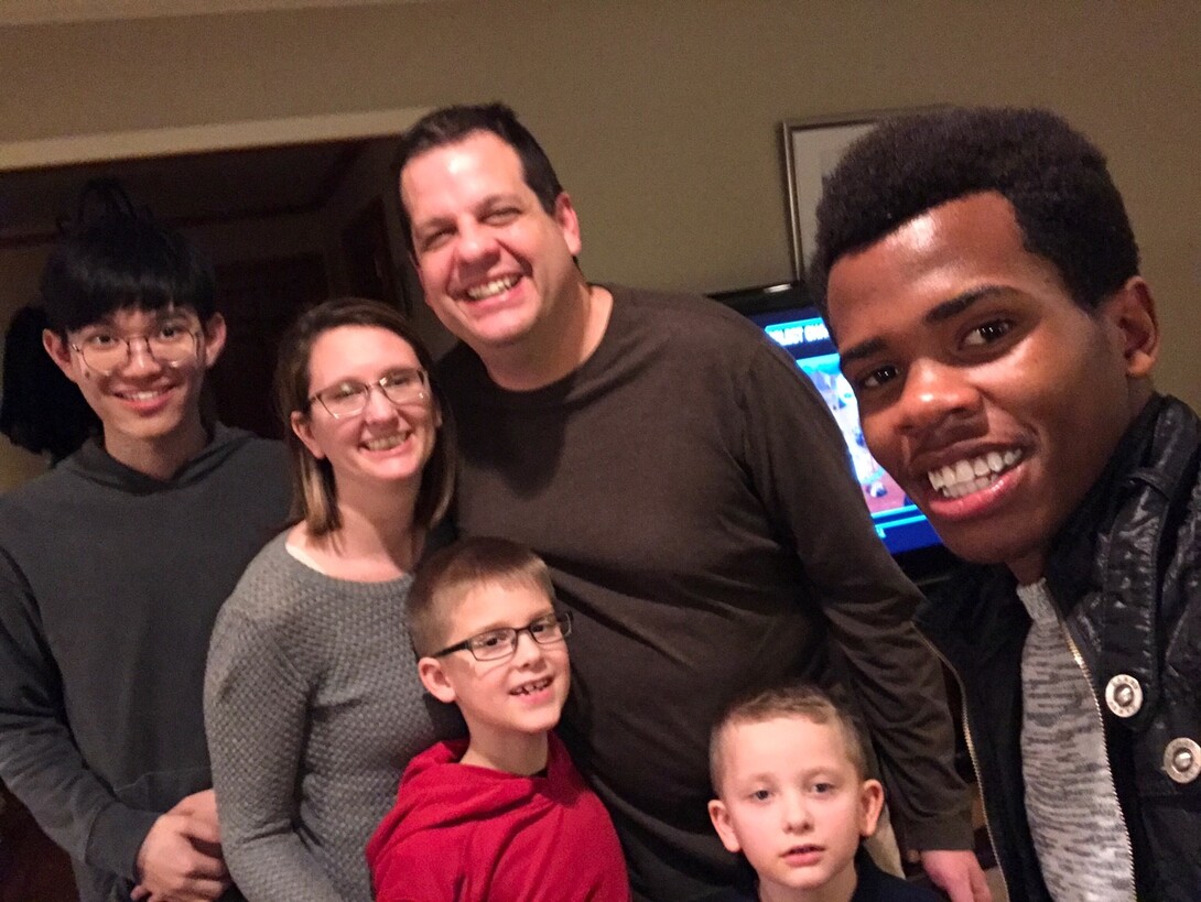 Lindsay Augustyn, assistant director and communications coordinator for the Center for Science, Mathematics and Computer Education, poses with her family and their two host students, Hang "Voyage" Yuan (left) and Thierry Bienvenu.