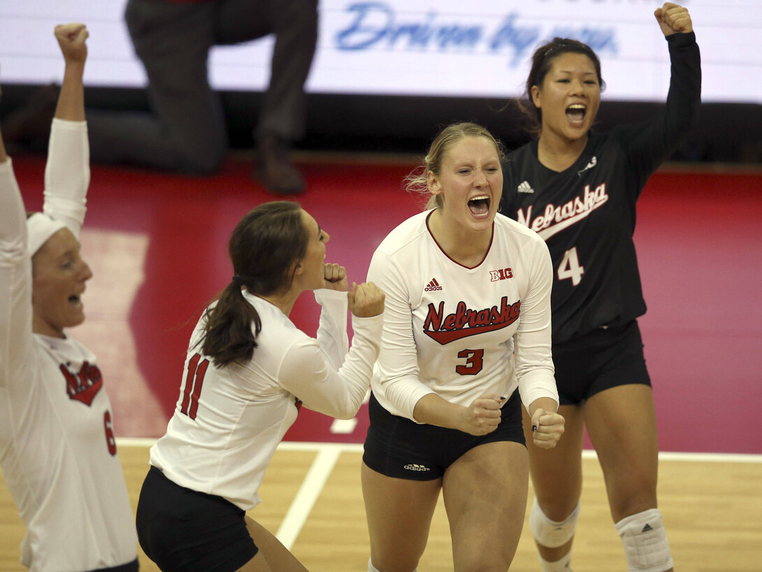 Husker volleyball players celebrate during a match.