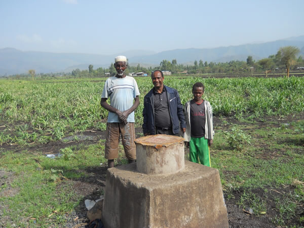 Tsegaye Tadesse, center, with a farmer and son at an irrigation demonstration site near Harbu, Ethiopia.